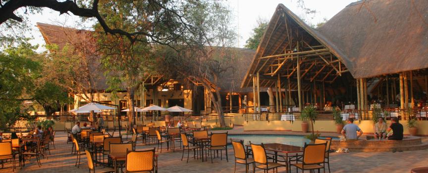 chobe safari lodge lodge exterior with dining tables in sunset