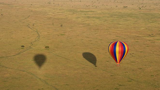 hot air balloon floating over the grassy plains